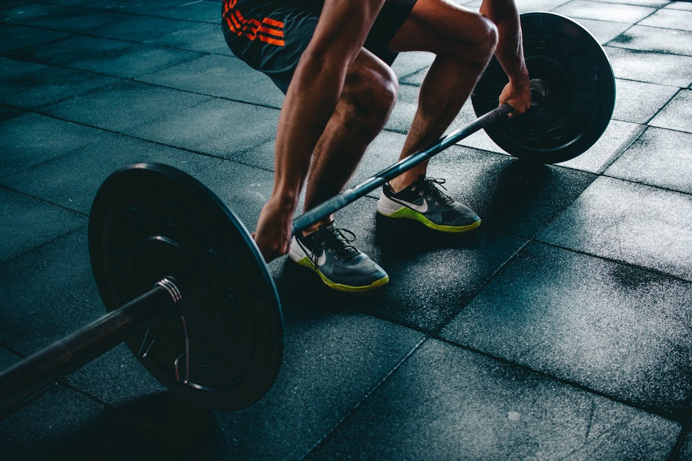 An athlete gripping a loaded barbell, set up to pull from the floor.